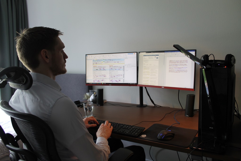 Wiebe translating at desk with computer and lamp